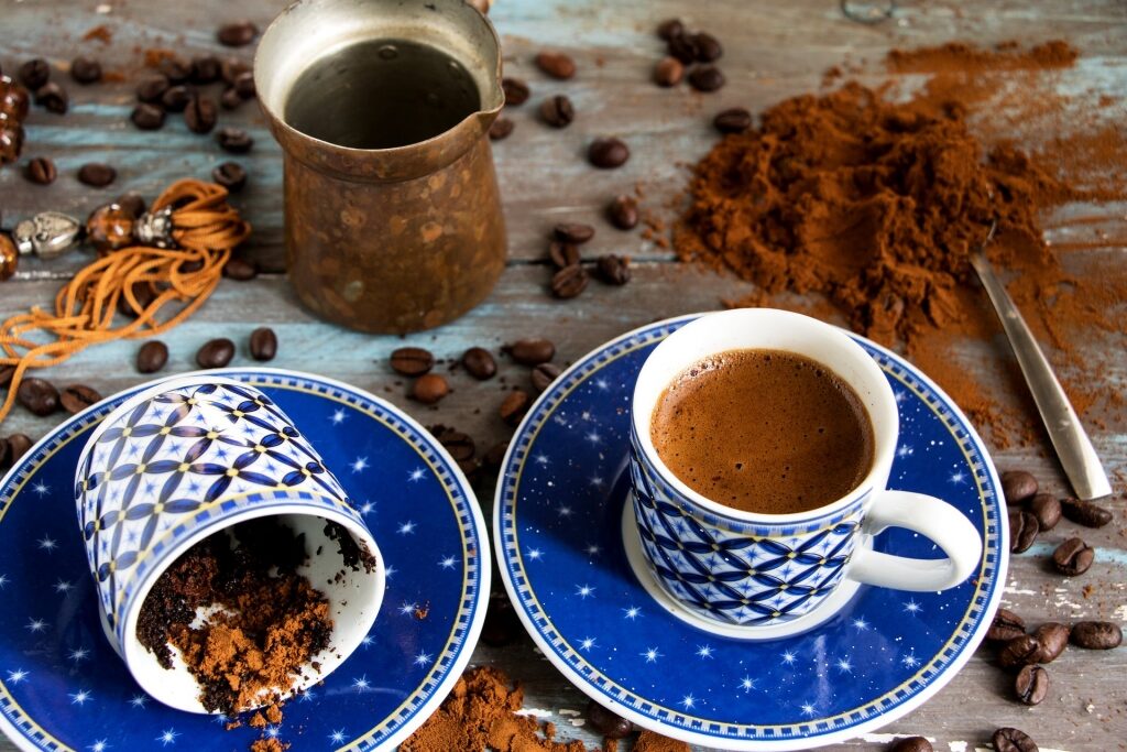 Cup of Greek coffee with briki coffee maker