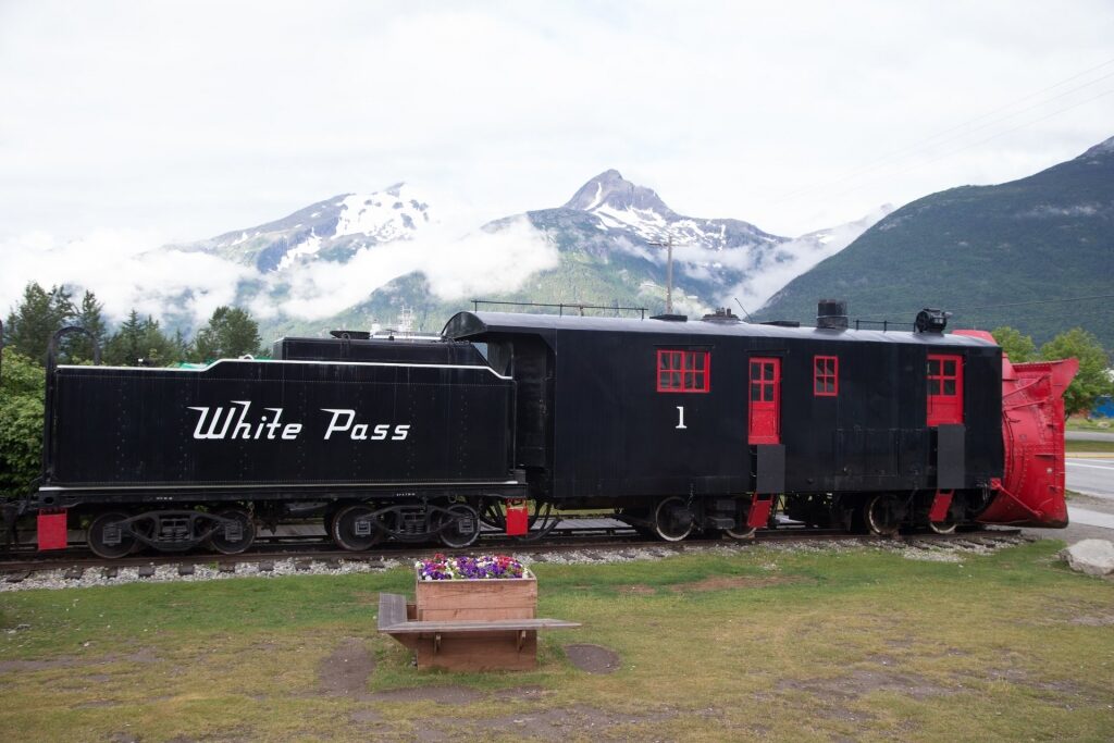 White Pass train in Alaska with snowy mountain as backdrop