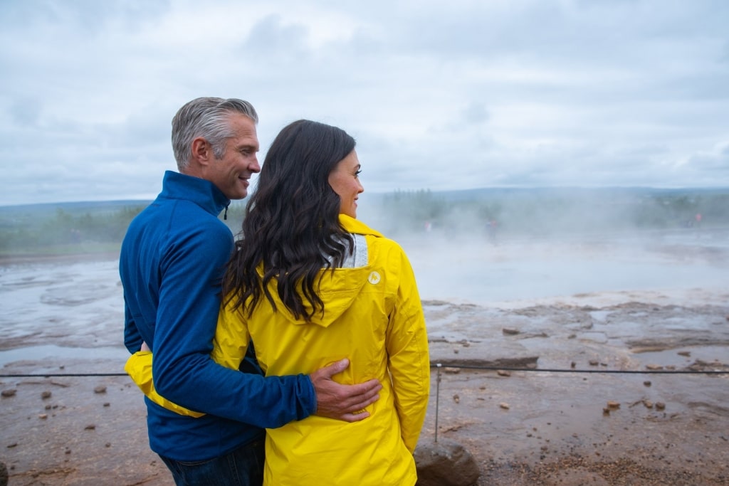 Couple looking at Geysir, Reykjavik, one of the best European honeymoon destinations