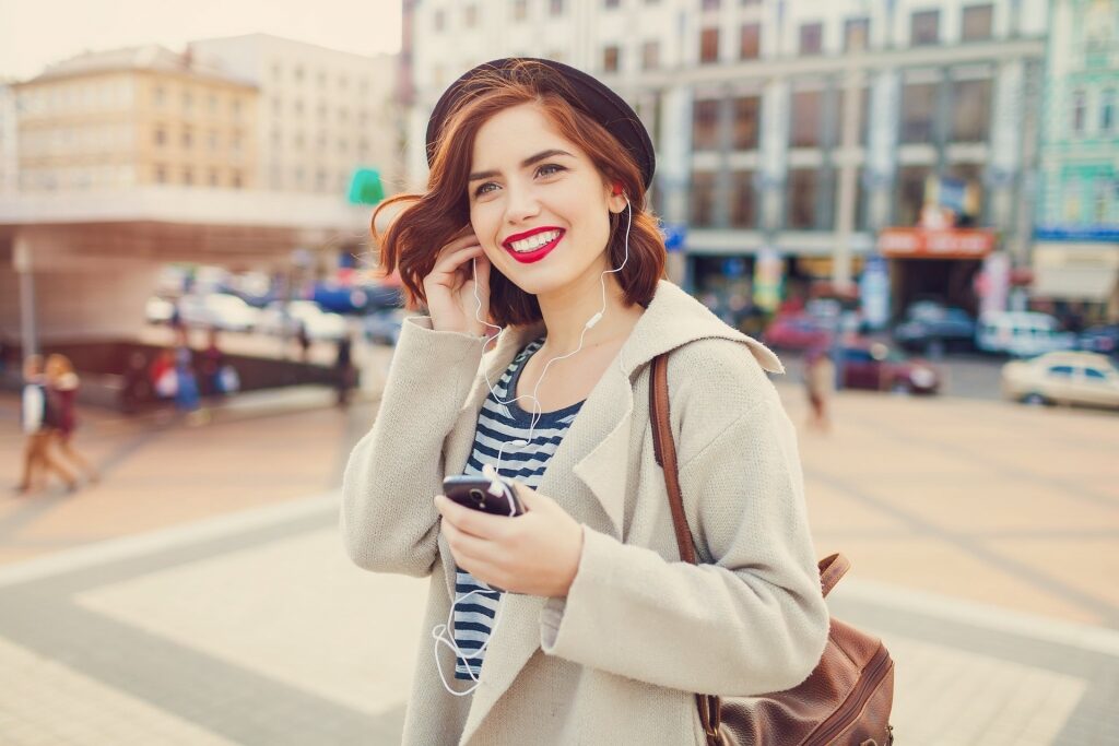 Woman wearing earphones while exploring European town