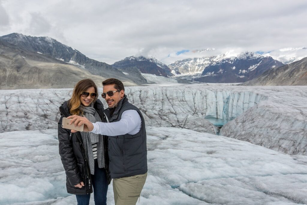 Couple taking a selfie with glaciers as backdrop