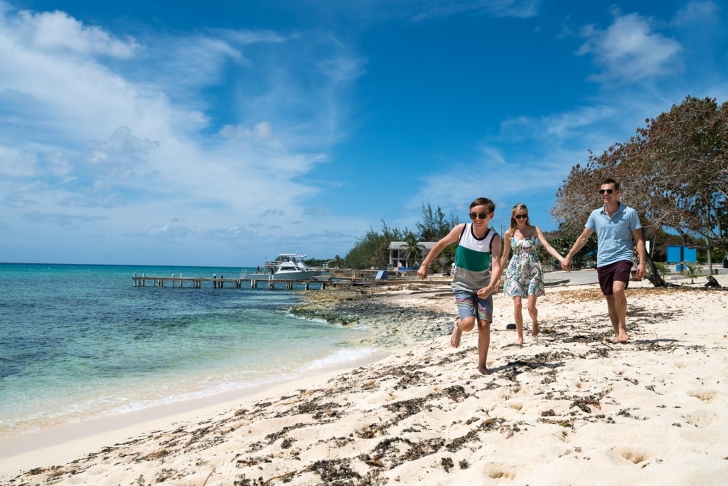 Family walking on white beach in Grand Cayman