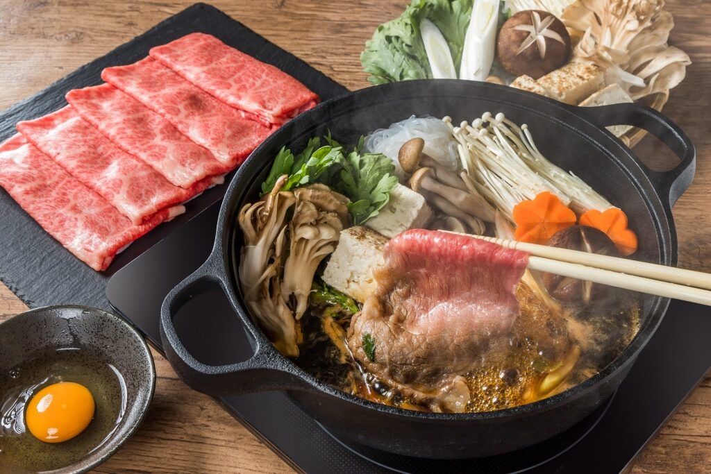 Sukiyaki pot filled with thin slices of meat