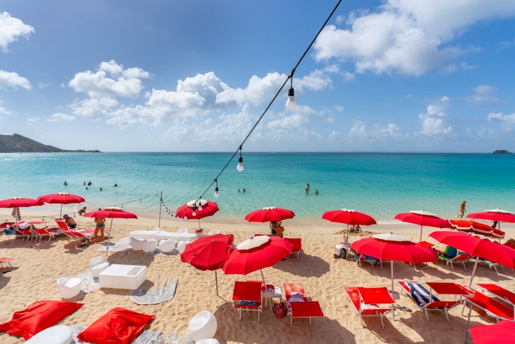 Red umbrellas and couches set up at a beach in St Maarten