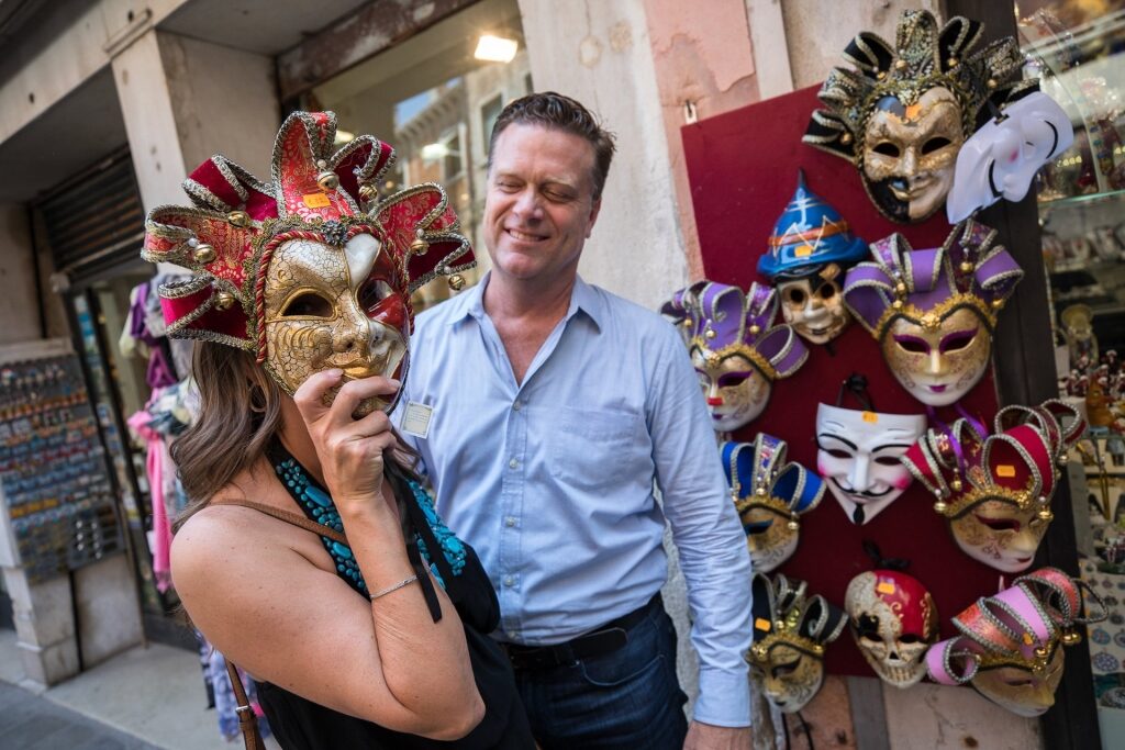 Couple checking out masks on a street in Venice