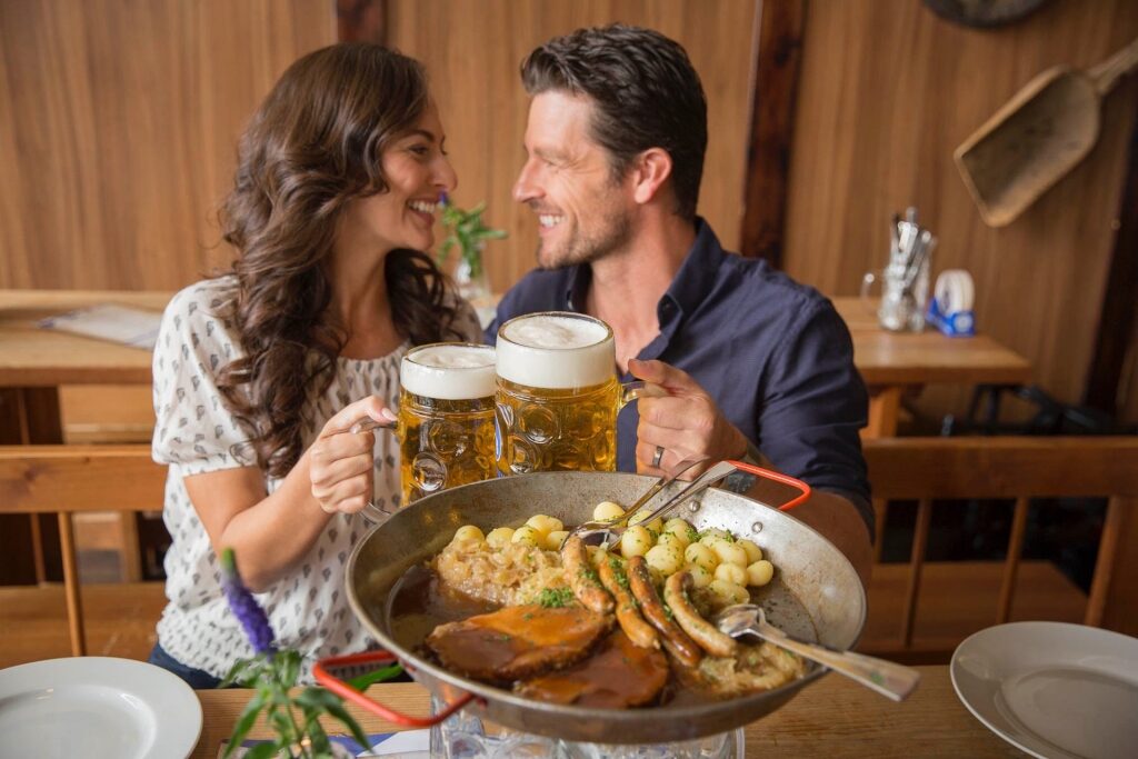 Couple enjoying German food and beer at a restaurant