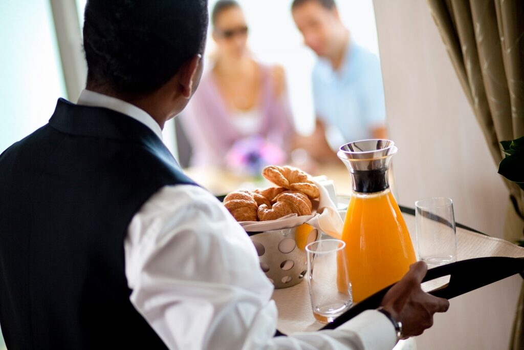 Butler serving food to guests on a stateroom
