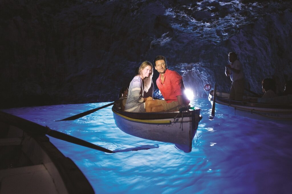 Couple on a boat inside Blue Grotto, Capri