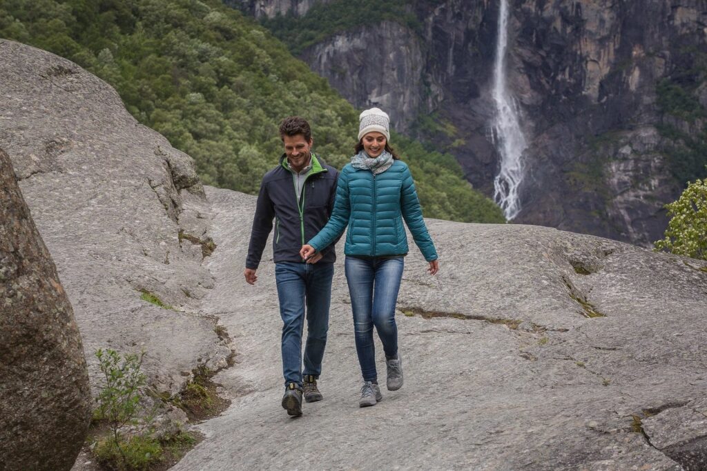 Couple hiking to a waterfall in Norway