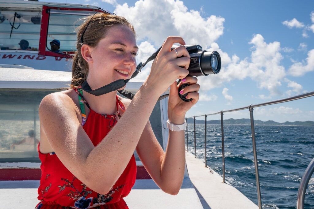 Woman on a boat holding her camera up to take pictures