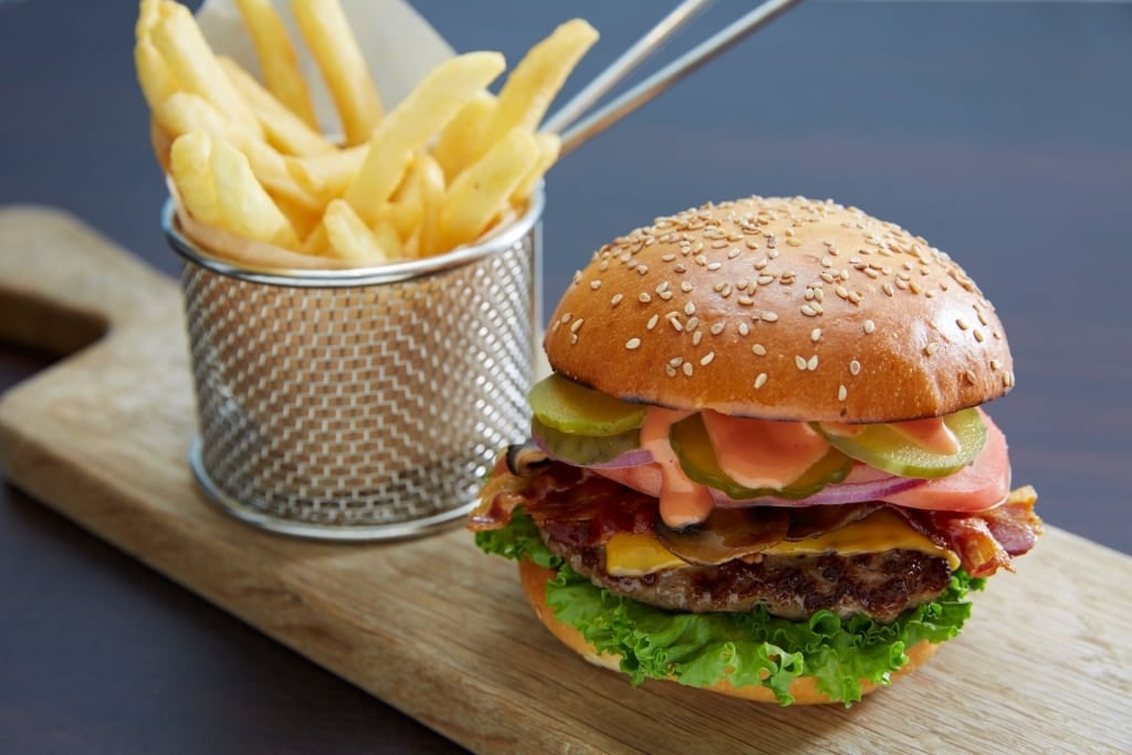 Delicious cheeseburger and fries on a wooden platter