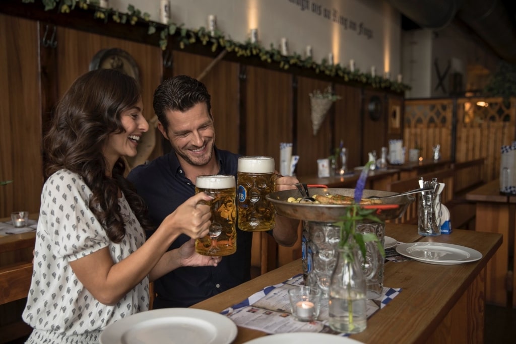 Couple raising their huge glass of beer for a toast