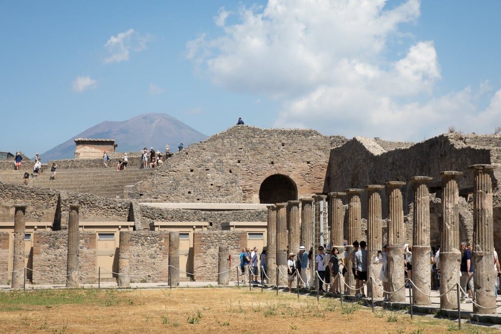 Tourists in Pompeii with Mount Vesuvius as backdrop