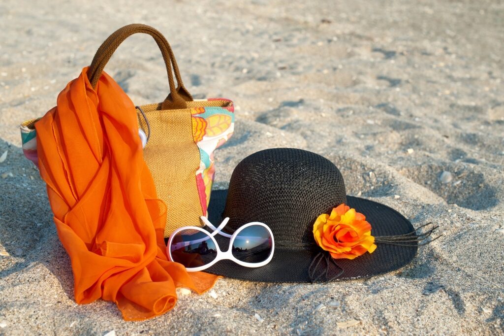 Scarf with sunglasses and hats on sandy beach