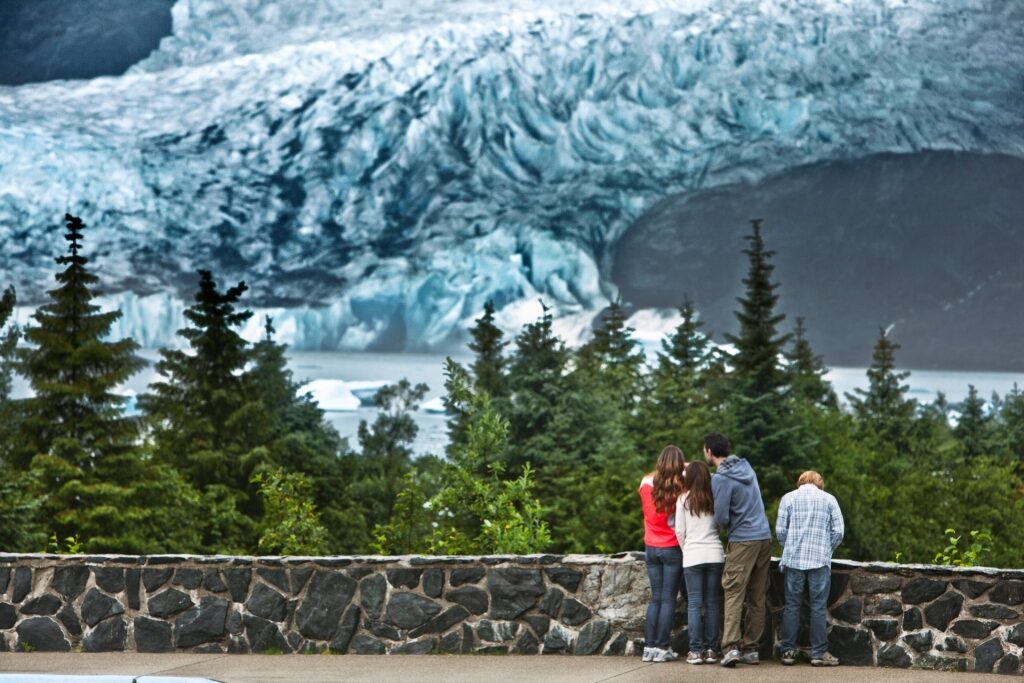 Tourists with Mendenhall Glacier backdrop in Alaska