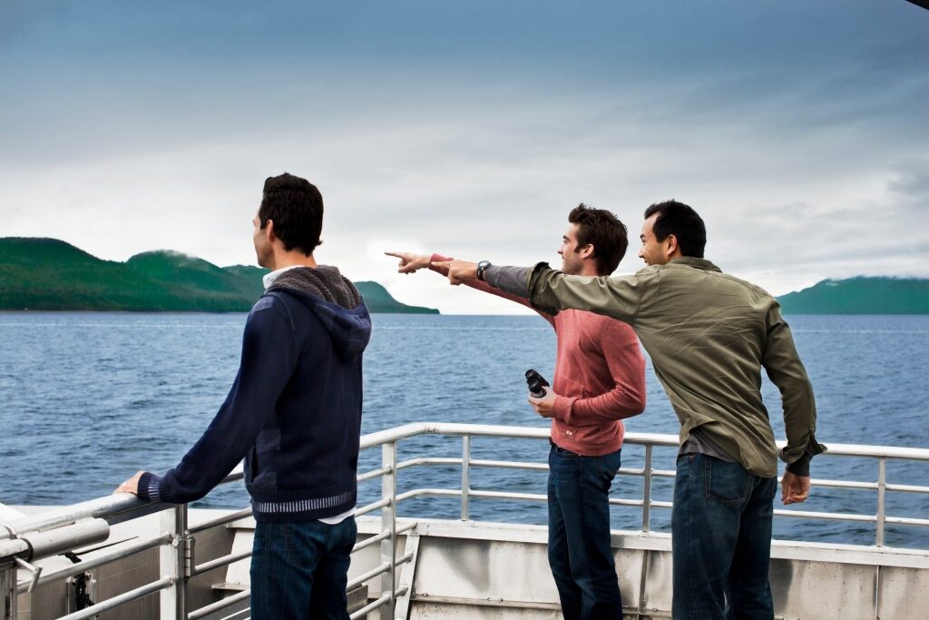 Friends enjoying an Alaska whale watching cruise with binoculars