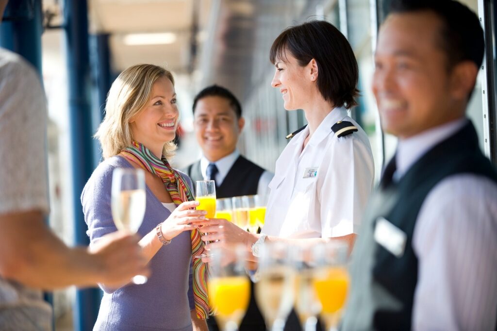 Woman being welcomed with drinks by crew
