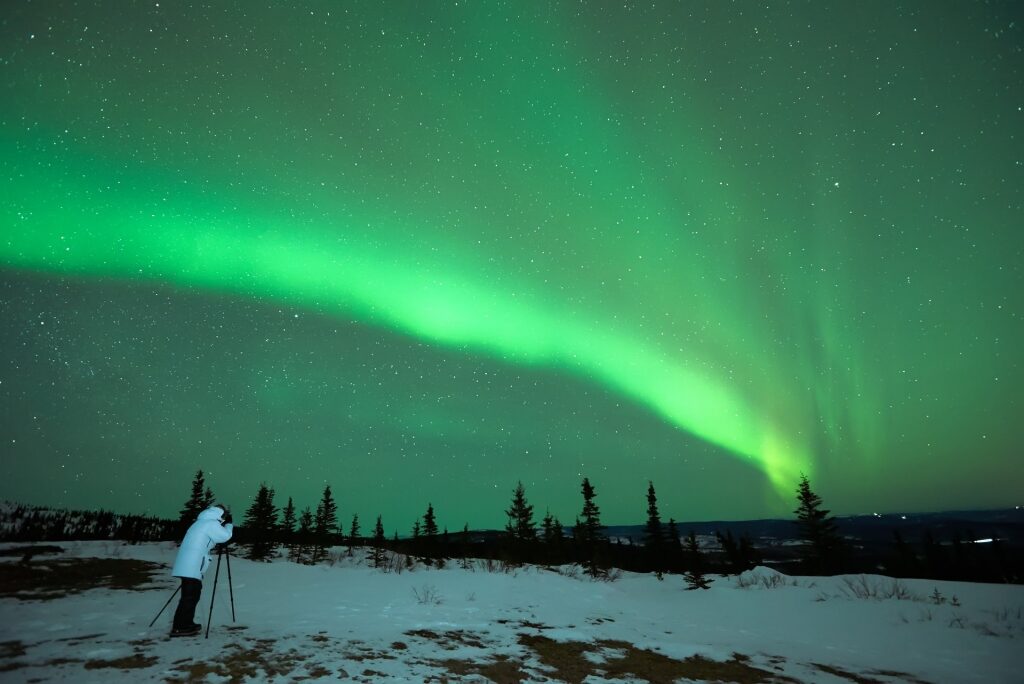 Person taking a photo of Northern Lights at night