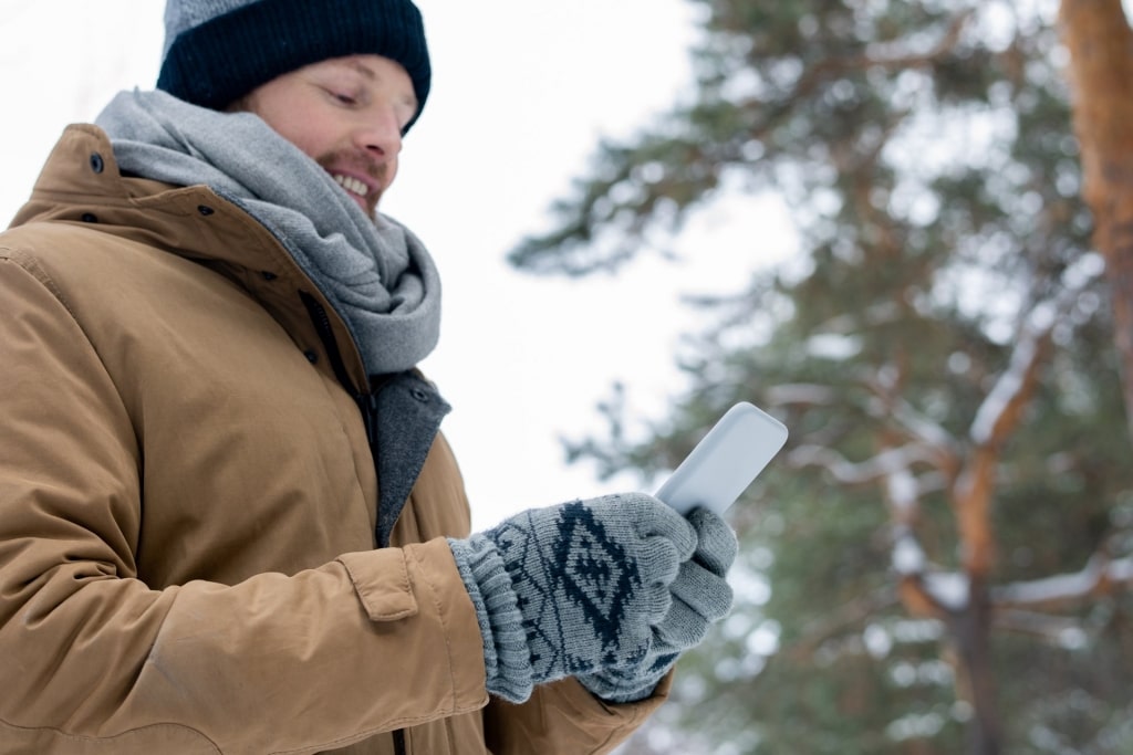 Man wearing gloves while texting