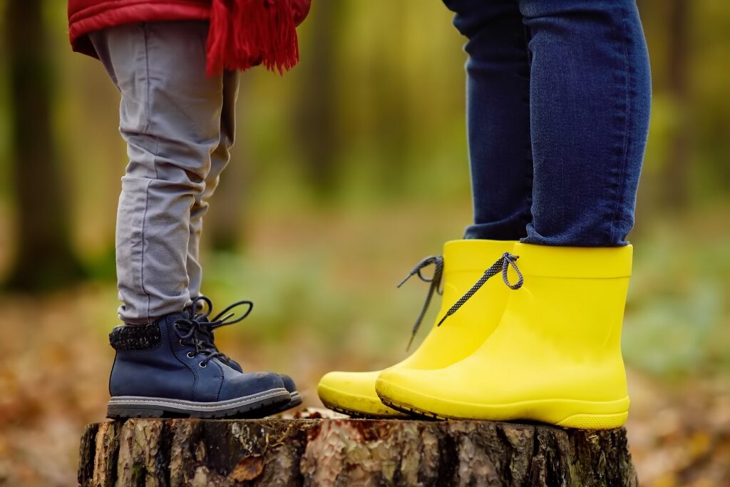 People wearing waterproof shoes while standing on a tree stump