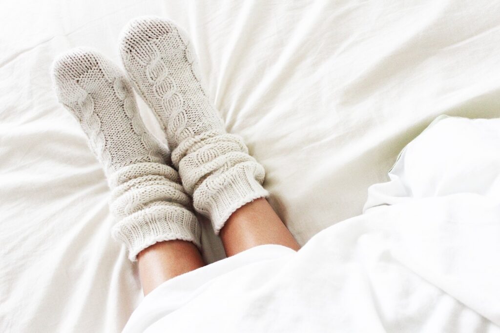 Person wearing wool socks in bed