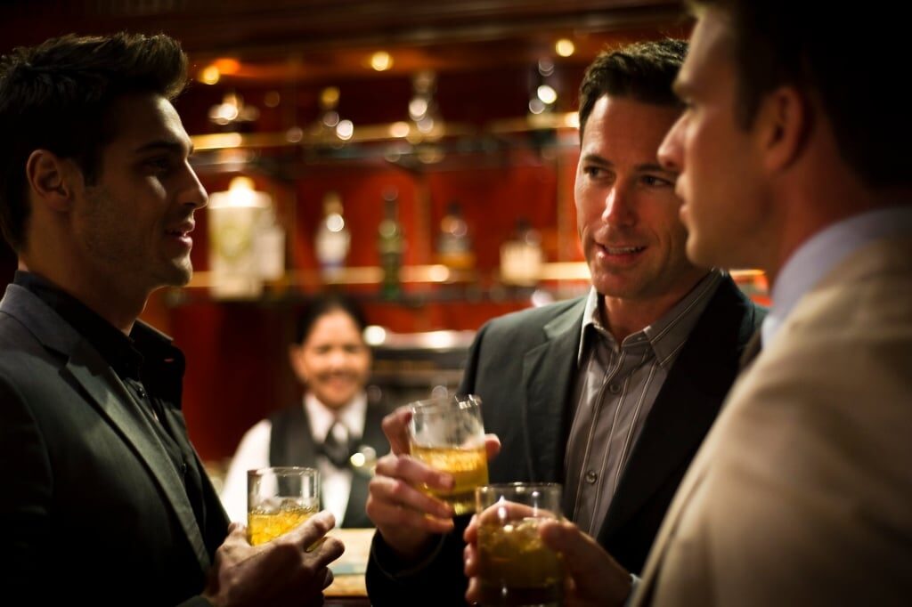 Gentlemen chatting over drinks at Michael's Club for Celebrity cruise nightlife