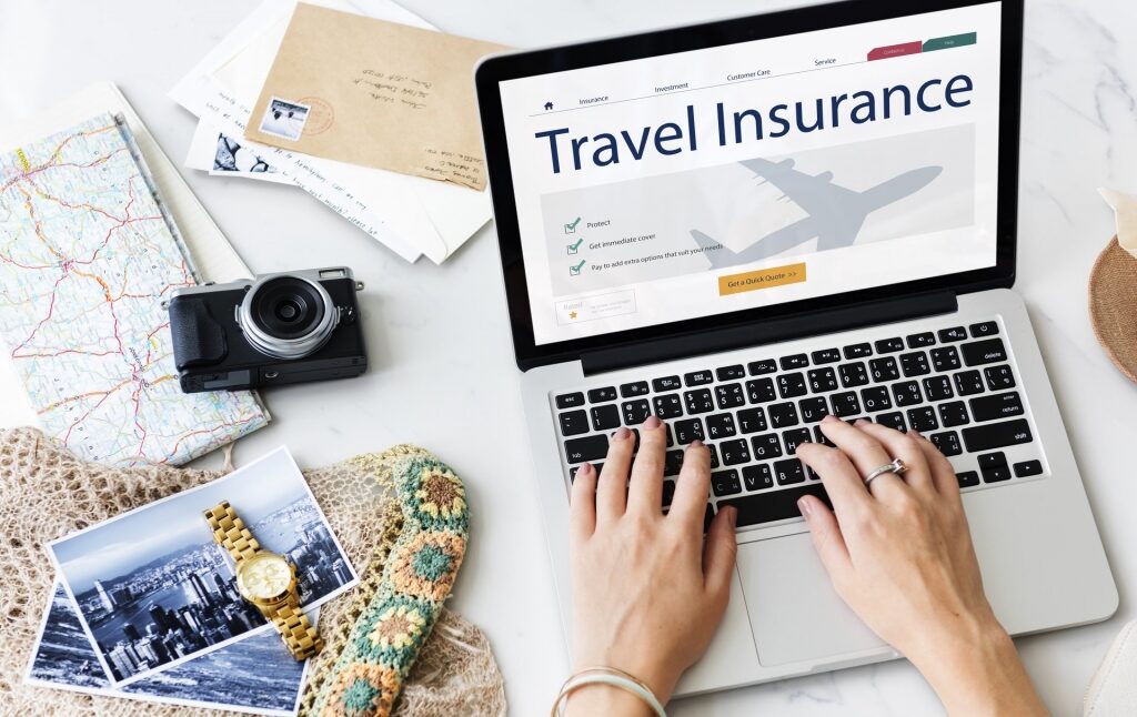Person searching for travel insurance on laptop