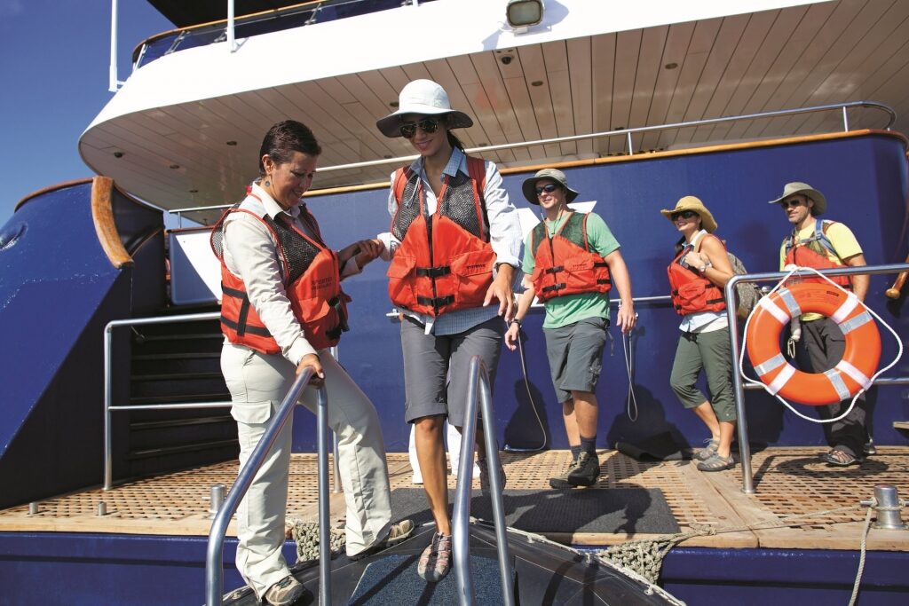 Guests with life jackets and hats preparing to go to an excursion in Galapagos Islands