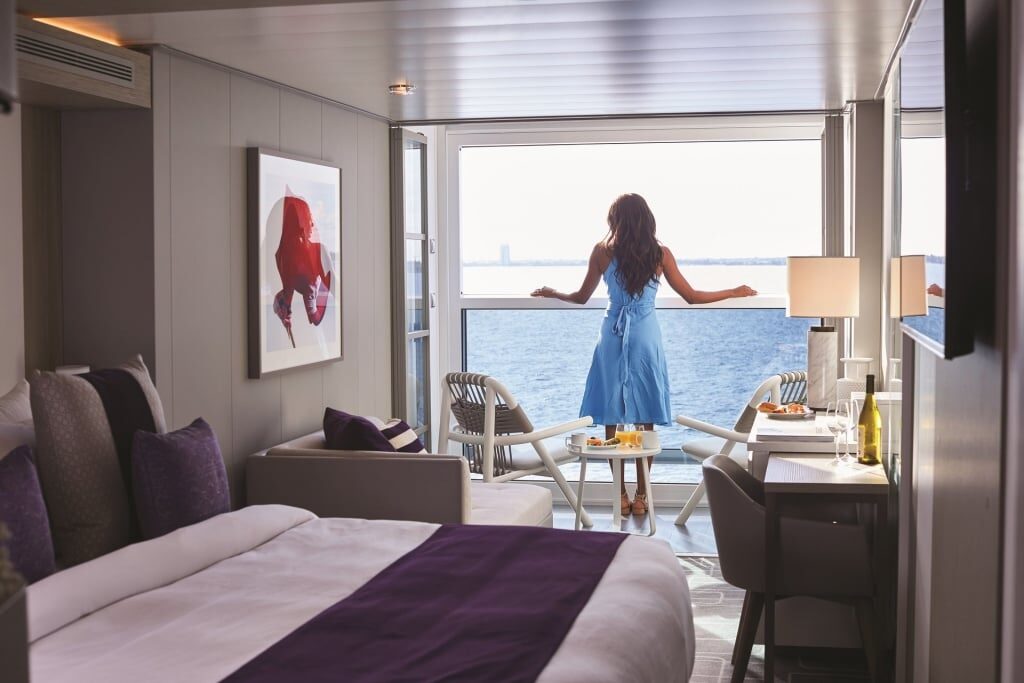 Woman standing on the balcony of Celebrity Cruises stateroom