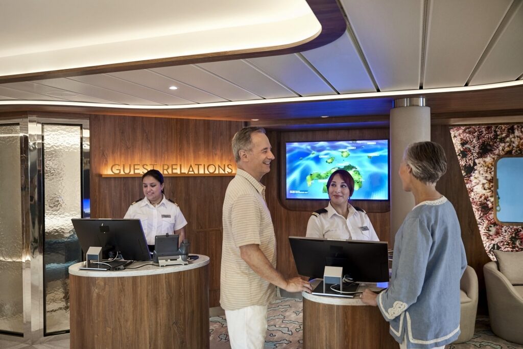 Guests inquiring at Guest Relations for onboard cruise credit