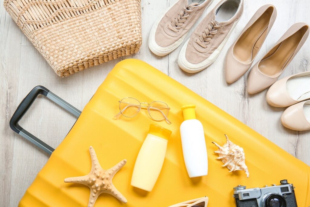 Yellow luggage with shoes, bag, and other essentials