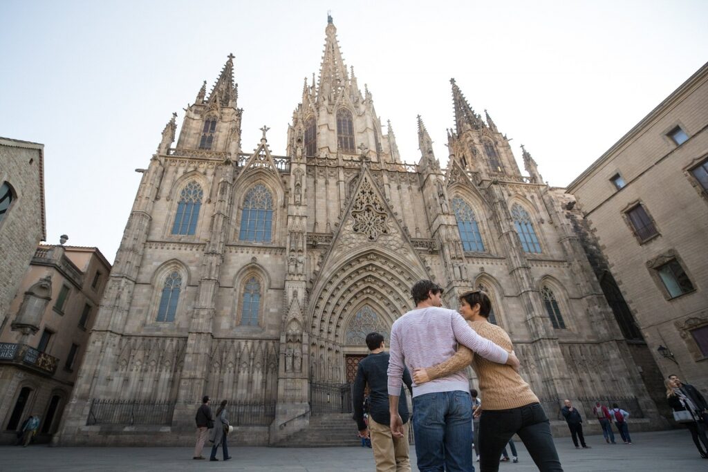 Couple walking towards Cathedral of Barcelona, Spain