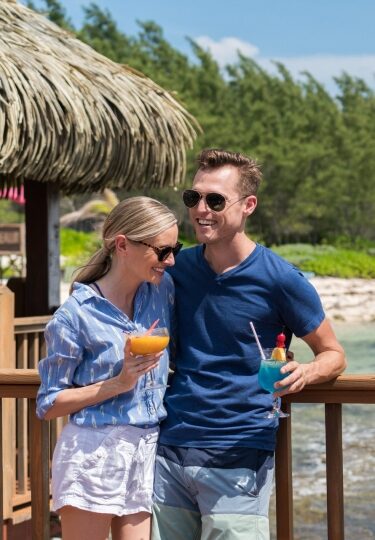 Couple enjoying cocktails by the beach