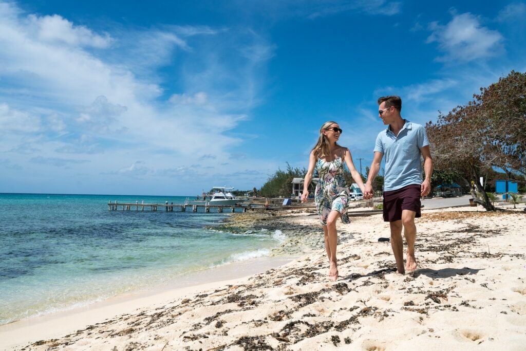 Couple walking on white beach in Grand Cayman
