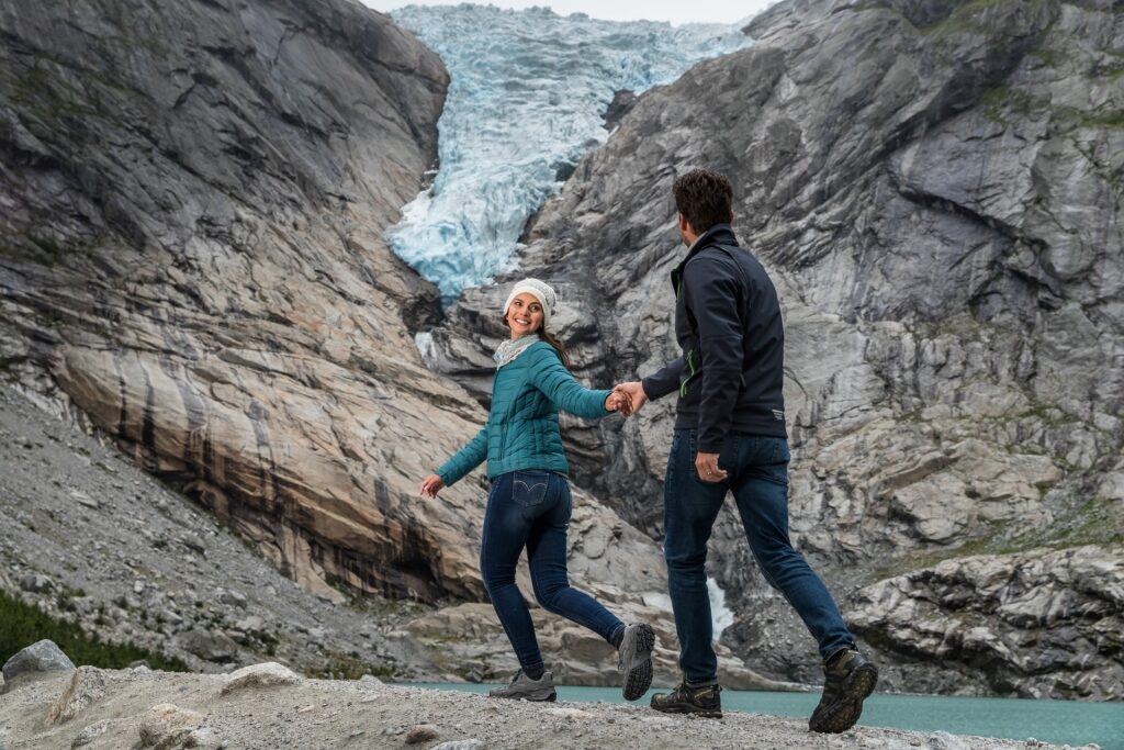 Couple exploring Briksdal Glacier, Norway