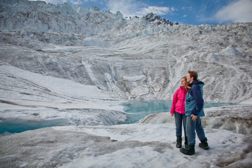 Couple sightseeing in Alaska atop glaciers