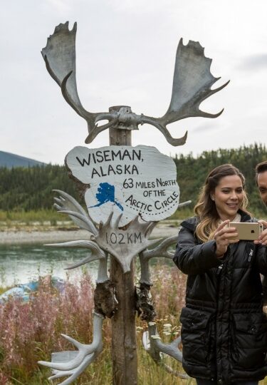 Couple taking a picture with Alaska signage