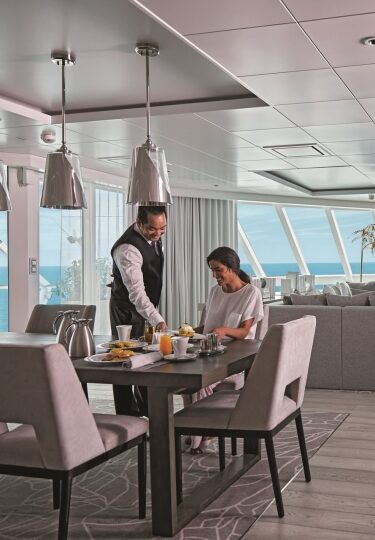 Woman being served with food inside cruise stateroom