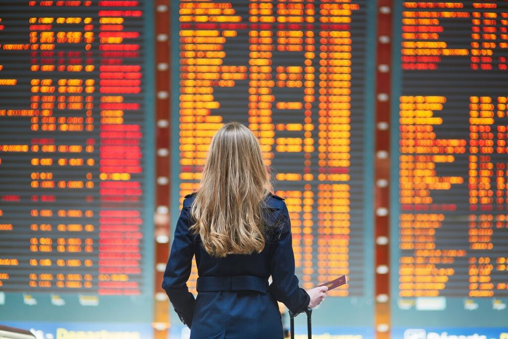 Woman checking airport schedule on screen