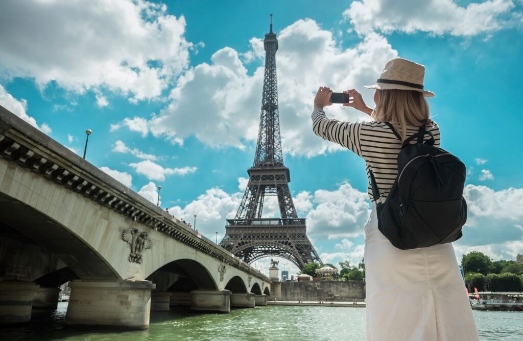 Woman taking a picture of the Eiffel Tower, Paris