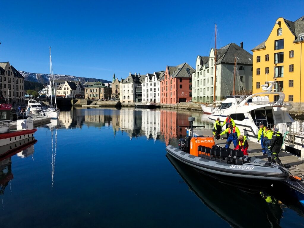 Colorful buildings in Alesund Norway reflecting on waters