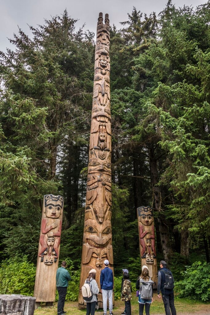 Tourists looking at totem poles in Alaska