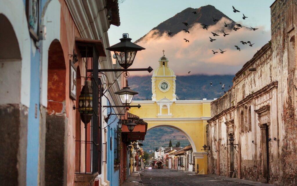 Old historical road in Guatemala, with a mountain in the background and birds flying
