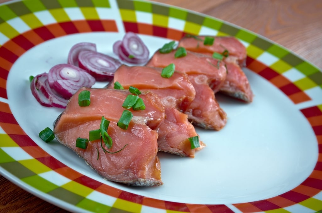 Norwegian food Rakfisk with red onioins on the side