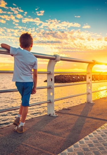 Kid watching the sunset from St Kilda Beach