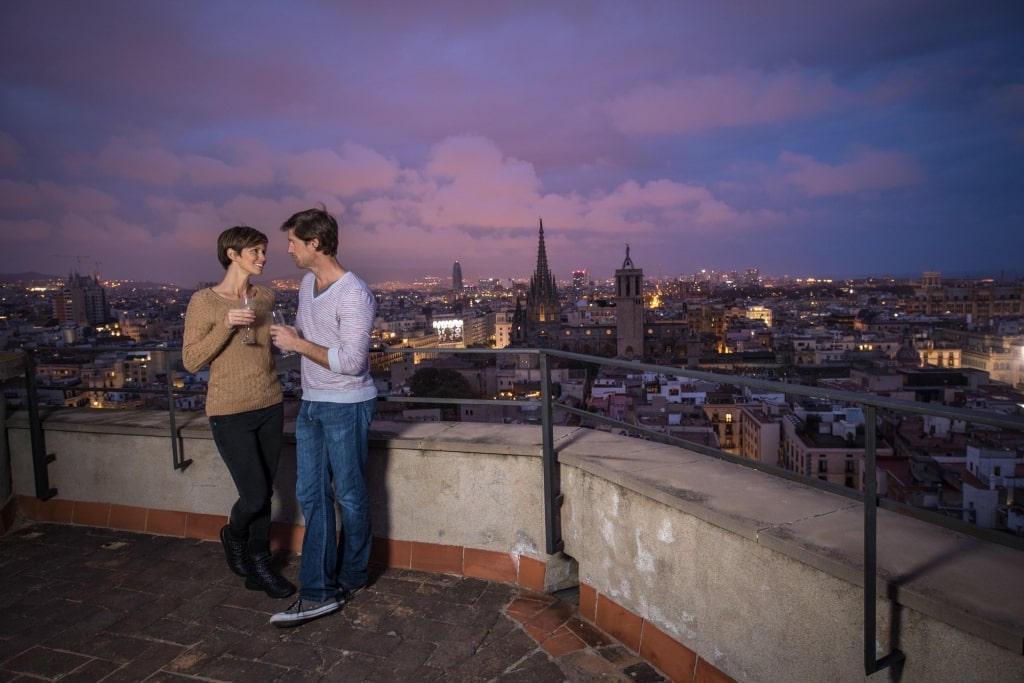 Couple drinking wine at the roofdeck with view of the city