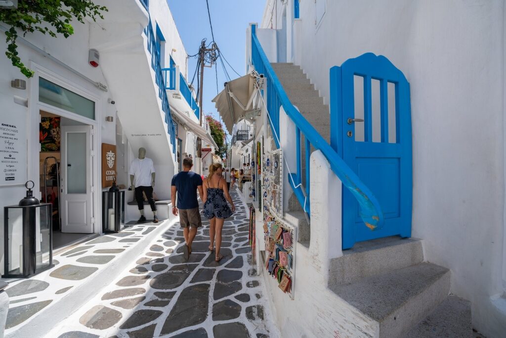 Couple walking along cobbled streets of Mykonos, one of the best Greek Islands for couples