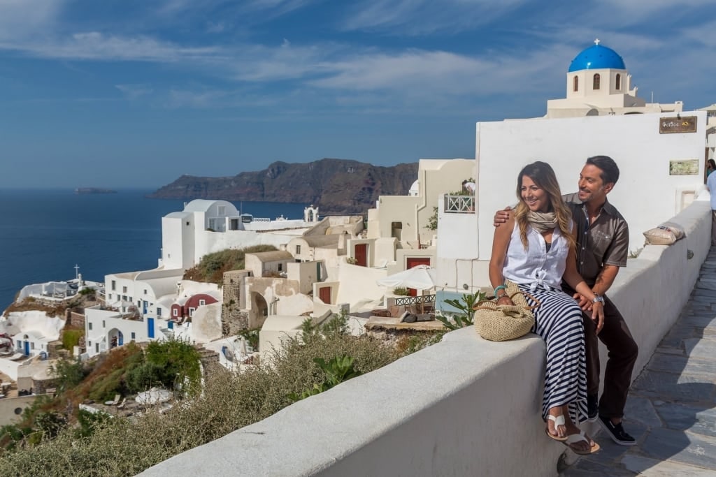 Couple sightseeing in Oia, Santorini, one of the best Greek Islands for couples