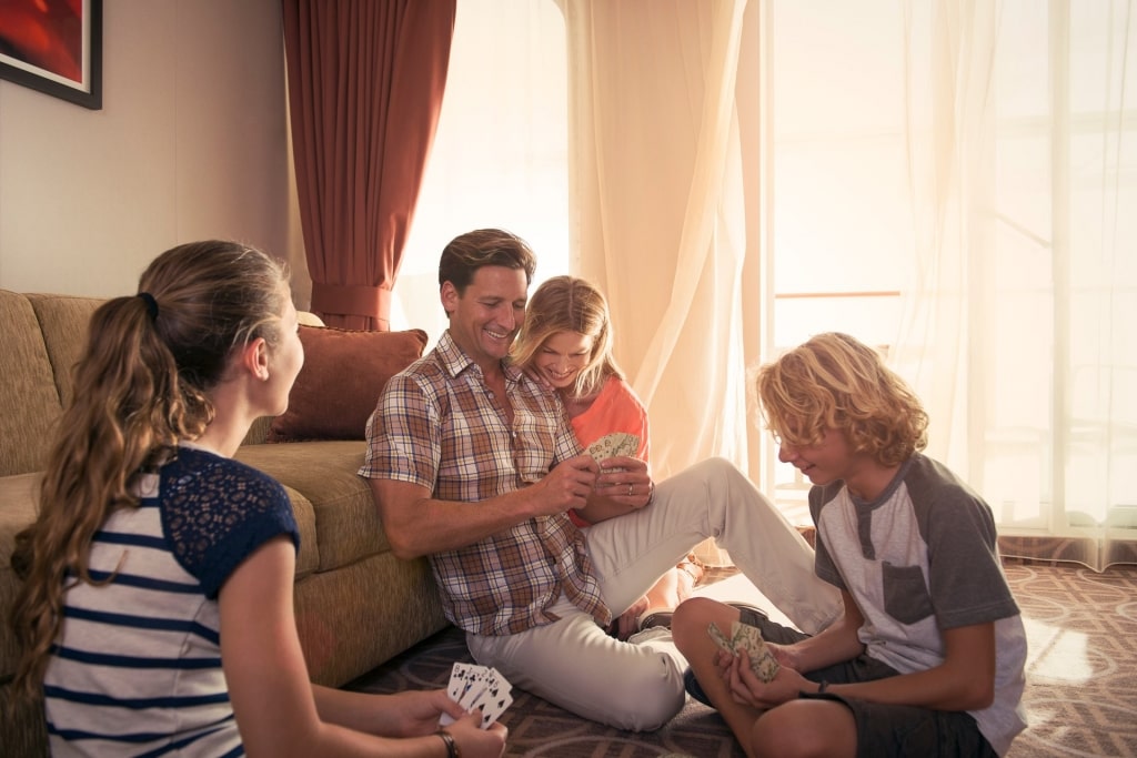 Family playing a card game on a cruise