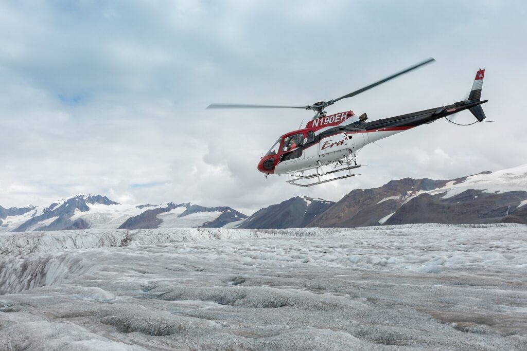 Helicopter flying over glacier field